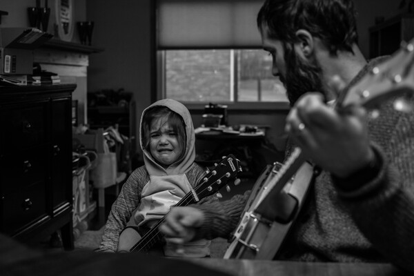 Daughter crying near dad with guitar