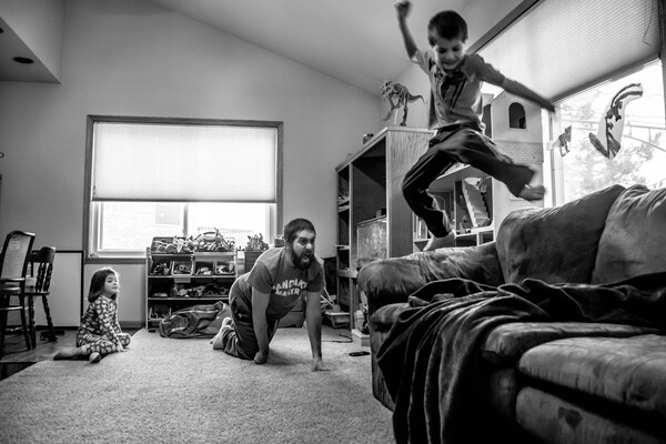 Dad playing with son who is jumping in the air